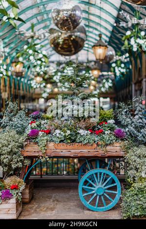 Ein Karren, riesige Kugeln und Misteln in Covent Garden, London während der Weihnachtszeit. Stockfoto