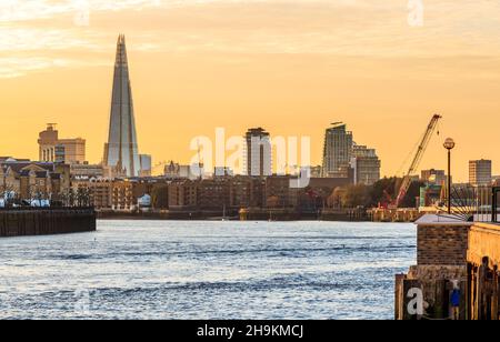 Blick flussaufwärts vom Themse Path am Limehouse, die Abendsonne beleuchtet den Shard und andere Stadtgebäude, London, Großbritannien Stockfoto