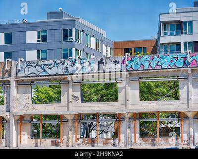 SEATTLE, USA - 4. AUGUST 2019: Neue Wohnungen in South Lake Union ragen hinter den teilweise abgerissenen Mauern des alten Zeitungsgebäudes der Seattle Times auf Stockfoto