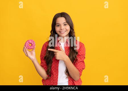 Happy Kid zeigen Finger auf süße glasierte Donut, Essen Stockfoto