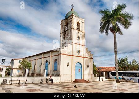 VINALES, KUBA - 25. DEZEMBER 2019: Am Weihnachtstag sitzt eine anonyme Person auf einer Bank auf dem platz vor der Hauptkirche in Vinales, Kuba Stockfoto