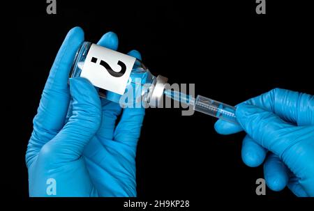 Hand in blauen medizinischen Handschuhen mit Glasflasche mit Fragezeichen, Spritze innen injiziert. Unbekanntes Impfstoffkonzept oder Konzept für Nebenwirkungen Stockfoto