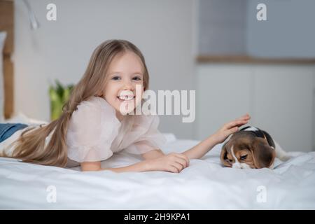 Fröhlich liebenswert kleines Mädchen streichelte ihren Welpen Stockfoto