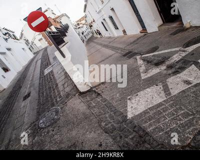 Ein Verbotsschild zwischen zwei typischen Straßen der Stadt Mijas in Málaga, an denen niemand vorbeikommt. Stockfoto