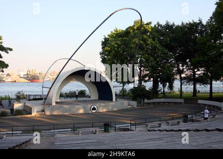 [Historisches] East River Park Amphitheater mit dem East River und dem Brooklyn Navy Yard im Hintergrund, New York, NY. Juli 2015 Stockfoto