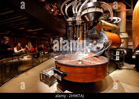 Die Menschen beobachten, wie frisch geröstete Kaffeebohnen aus einer großen Probat-Rösterei im Starbucks Reserve Roastery New York strömen. Stockfoto