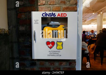 Ein Cintas Reviver zeigt medizinische Notfallgeräte des automatisierten externen Defibrillators (AED) an, die in einem Wandschrank in einem öffentlichen Raum aufbewahrt werden. Stockfoto