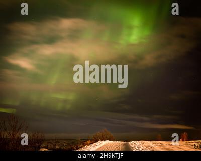 Grüne Nordlichter über der Stadt Hafnarfjordur, Island. Winternacht, keine Menschen. Stockfoto