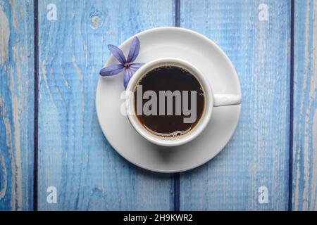 Kaffee. Weiße Tasse Kaffee auf einem blauen Holztisch. Stockfoto