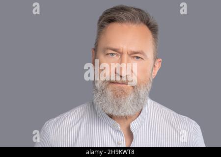Männlicher Geschäftsmann in einem weißen Hemd, der selbstbewusst aussieht Stockfoto