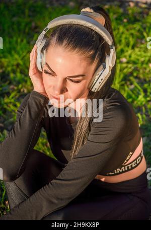 Nettes sportliches Mädchen mit Kopfhörern, Musik hören./schöne Frau genießt das Hören von Musik. Stockfoto