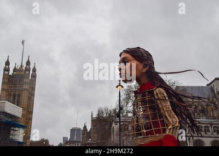 London, Großbritannien. 07th Dez 2021. Während der Demonstration ist die kleine Amal, eine Marionette, vor dem Parlament zu sehen.Demonstranten versammelten sich auf dem Parlamentsplatz mit der Marionette kleine Amal, die ein syrisches Flüchtlingskind darstellt, zur Unterstützung von Flüchtlingen und aus Protest gegen das von der Regierung debattierte Gesetz über Nationalität und Grenzen. Kredit: SOPA Images Limited/Alamy Live Nachrichten Stockfoto