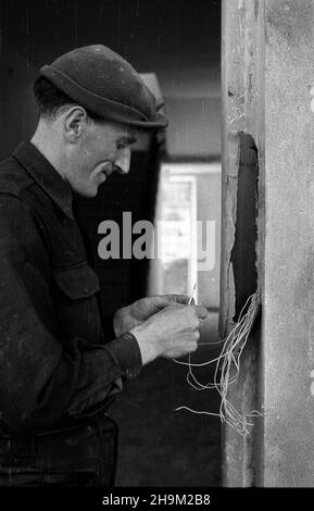 Warszawa, 1948-09. Budowa siedla mieszkaniowego przodowników pracy na Mariensztacie wed³ug projektów zespo³u architektów pod kierownictwem Zygmunta Stêpiñskiego i Józefa Sigalina. NZ. Montowanie instalacji elektrycznej. msa PAP Dok³adny dzieñ wydarzenia nieustalony. Warschau, September 1948. Die Wohnsiedlung Mariensztat für Helden der Arbeit wird nach dem Entwurf eines Architektenteams unter der Leitung von Zygmunt Stepinski und Jozef Sigalin errichtet. Abbildung: Befestigung der Verkabelung. msa PAP Stockfoto