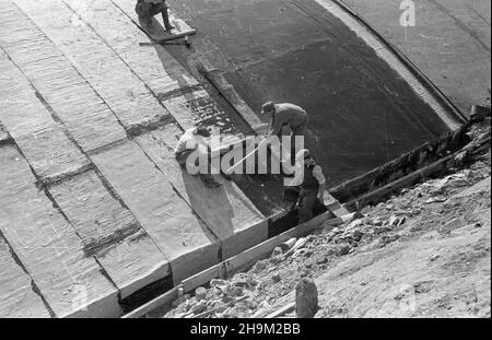 Warszawa, 1948-09. Budowa Trasy W-Z (Trasa Wschód-Zachód). NZ. uk³adanie papy na zbudowanym odcinku tunelu przy placu Zamkowym. msa PAP Dok³adny dzieñ wydarzenia nieustalony. Warschau, September 1948. Der Bau der W-Z (Ost-West-Route). Im Bild: Arbeiter, die den fertigen Abschnitt eines Tunnels auf dem Zamkowy-Platz mit Teerpapier bedecken. msa PAP Stockfoto