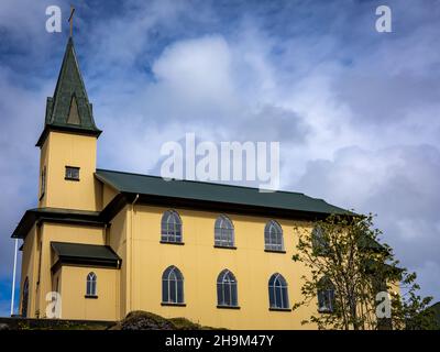 Hafnarfjordur, Island - 17. Juli 2021: Eine Kirche aus Frikirkjan im Stadtzentrum. Traditionelle isländische Architektur, gelbe Wände, grünes Dach. Stockfoto