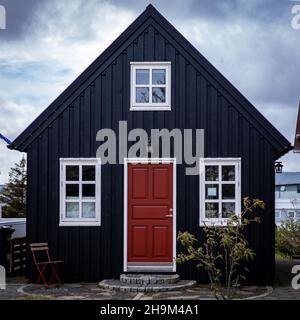 Hafnarfjordur, Island - 17. Juli 2021: Ein schwarzes, traditionelles isländisches Holzhaus. Wolkiger Himmel. Keine Personen. Stockfoto