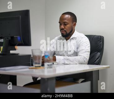 Junger afroamerikanischer CEO, der in seinem Büro arbeitet Stockfoto