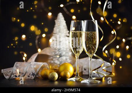 Zwei Sektgläser und weihnachtsdekorationen auf dunklem festlichem Hintergrund. Frohes neues Jahr. Stockfoto