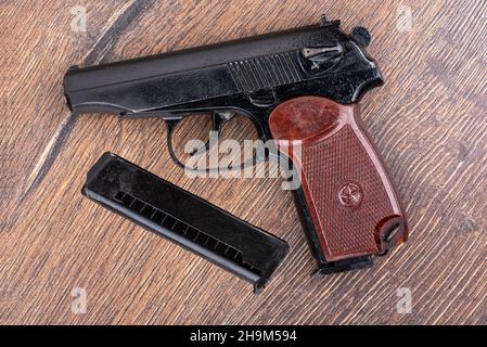 Draufsicht auf die Makarov Pistole und das Magazin für die Patrone auf einem Holzhintergrund. Die Hauptwaffe der russischen Polizei. Stockfoto