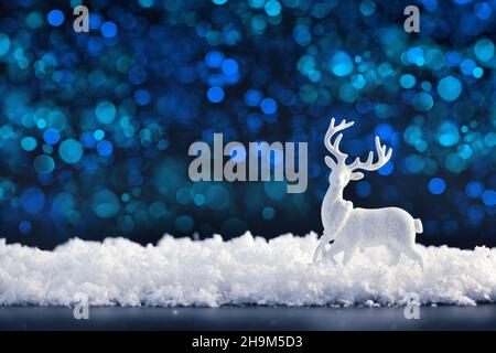 Weiße weihnachtshirsche auf dem Schnee auf einem dunklen festlichen Hintergrund. Frohe Weihnachten und Frohes neues Jahr. Stockfoto