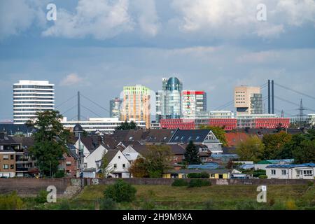 Die Skyline von Düsseldorf, mit den Wolkenkratzern im Medienhafen, Rheinbrücken, vor Wohnhäusern am Rhein im Hamm-Viertel, Stockfoto