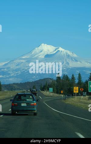 SISKIYOU COUNTY, VEREINIGTE STAATEN - 05. Dez 2021: Eine vertikale Ansicht auf einem schneebedeckten Mount Shasta von der Autobahn mit Autos in Siskiyou County, Nord-Cal Stockfoto