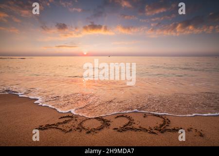 Sonnenaufgang über dem Strand. Neujahr 2022 Text auf dem Sand Stockfoto
