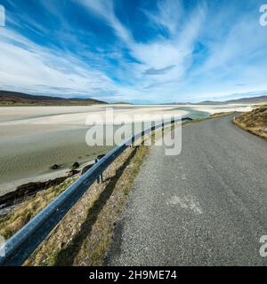 Straße und Armco-Barriere am wunderschönen Strand von Luskentyre (Traigh Losgaintir) auf der abgelegenen Isle of Harris in den Äußeren Hebriden, Schottland, Großbritannien Stockfoto