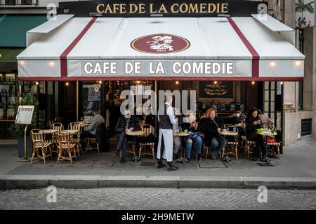 Blick auf die Straße mit Tischen des Cafés oder Restaurants in Paris, Frankreich. Stockfoto