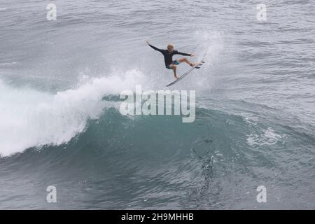 Nicht erkennbarer, arobatischer Surfer, der auf Maui eine große Welle in der Luft reitet. Stockfoto