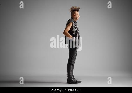 Ganzkörperaufnahme eines Punkers mit einem auf grauem Hintergrund isolierten Mohawk Stockfoto