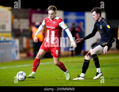 Archie Collins von Exeter City (links) und Paul Lewis von Northampton Town kämpfen während des zweiten Spiels der Sky Bet League im St James Park, Exeter, um den Ball. Bilddatum: Dienstag, 7. Dezember 2021. Stockfoto