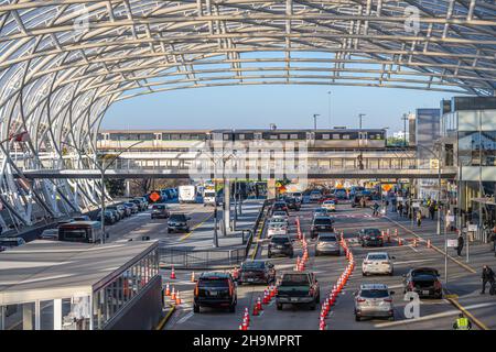 Geschäftiges morgendliches Verkehrsaufkommen am Hartsfield-Jackson Atlanta International Airport mit Autos, Flughafen-Shuttles, Reisenden Fußgängern und einem Marta-Schnellzug. Stockfoto