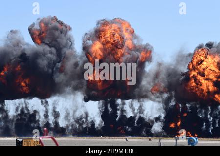 Rauch und Flamme von simulierten Geschossen entzündet sich in der Nähe der Startbahn während der MAGTF-Demo auf der MCAS Miramar Airshow Stockfoto