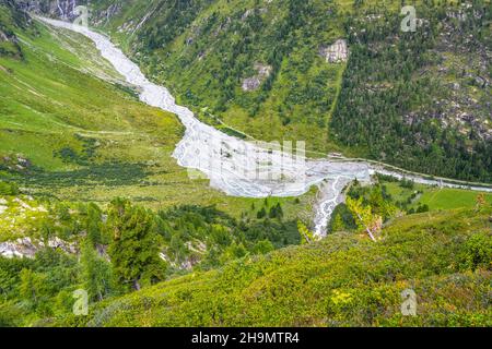 Enger gedrehter felsiger Bach im alpinen Tal Stockfoto