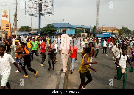 Lagos, Nigeria, 7th. Dezember 2021. Demonstranten fliehen vor Polizeitrengas am Gymnasium in Ojodu, Lagos, Nigeria, wo ein Lieferwagen, der angeblich von Verkehrsbeamten verfolgt wurde, einige Studenten tötete, die von der Schule zurückkehrten. Während der Augenzeuge sagte, dass mindestens 17 Schüler starben, bestätigte die Polizei am Dienstag, dass drei Tote, 12 Verletzte, bei dem Unfall starben. Foto von Adekunle Ajayi Stockfoto