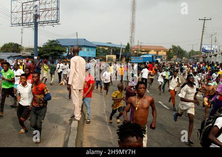 Lagos, Nigeria, 7th. Dezember 2021. Demonstranten fliehen vor Polizeitrengas am Gymnasium in Ojodu, Lagos, Nigeria, wo ein Lieferwagen, der angeblich von Verkehrsbeamten verfolgt wurde, einige Studenten tötete, die von der Schule zurückkehrten. Während der Augenzeuge sagte, dass mindestens 17 Schüler starben, bestätigte die Polizei am Dienstag, dass drei Tote, 12 Verletzte, bei dem Unfall starben. Foto von Adekunle Ajayi Stockfoto