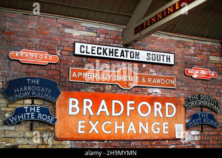 Eisenbahnmemorabilien, Bahnhofsschilder und Bahnnamenschilder, die an einer Wand des Bradford Industrial Museum West Yorkshire angebracht sind. Stockfoto