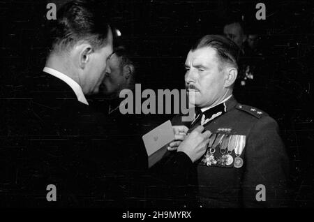 Warszawa, 1948-10-09. Uroczysta akademia w klubie MBP (Ministerstwa Bezpieczeñstwa Publicznego) przy al. Wyzwolenia z okazji czwartej rocznicy istnienia Milicji Obywatelskiej. W prezydium zasiedli: minister bezpieczeñstwa publicznego Stanis³aw Radkiewicz, gen. Franciszek JóŸwiak ps. Witold, Wiceminister obrony narodowej gen. Piotr Jaroszewicz, gen. Konrad Œwietlik i przedstawiciele delegacji zagranicznych. NZ. minister Radkiewicz (L) dekoruje odznaczeniami cz³onków delegacji zagranicznych i zas³u¿onych funkcjonariuszy MO. mw PAP Warschau, 9. Oktober: Die Gala zum 4th. Jubiläum Stockfoto