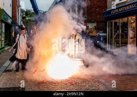 Mitglieder der Cliffe Bonfire Society, die in religiösem Kostüm gekleidet waren, zogen vor der jährlichen Bonfire Night Celebrations, Lewes, Großbritannien, Feuerwerkskörper auf der Straße aus Stockfoto