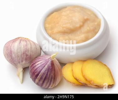 Ingwer und Knoblauch mit Paste auf weißem Hintergrund Stockfoto