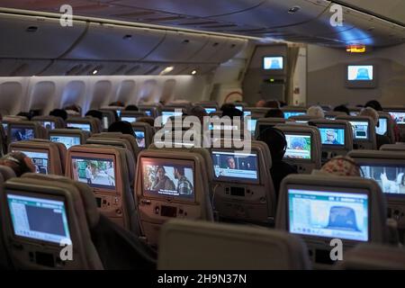 Innenraum der Flugzeugkabine, Passagiere schauen sich Filme an Stockfoto