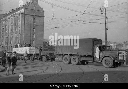 Warszawa, 1948-10-20. Zniszczona w styczniu 1945 r. Kolumna Zygmunta III Wazy zosta³a odbudowana z inicjatywy pracowników Pañstwowych Kamienio³omów. Trzon kolumny wykuto z 30-tonowego bloku granitowego o d³ugoœci 10 metrów, wydobytego w kamienio³omie ¯bik w Strzegomiu i przewiezionego kolej¹ do Warszawy. Dalej Transport odbywa³ siê na specjalnej lawecie, której obs³ugê stanowili robotnicy firmy C. Hartwig: Zaj¹c, Glinka, Janke, czy¿ewski, Dembowski, Wnuk i Kisiel. NZ. kolumna transportowa na rogu ul. ¯elaznej i Al. Jerozolimskich. pw PAP Warschau, 20. Oktober 1948. Der König König Sigismundus Stockfoto