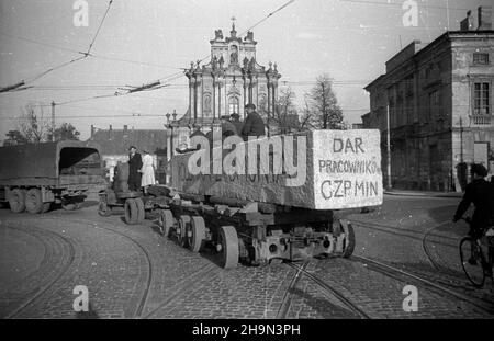 Warszawa, 1948-10-20. Zniszczona w styczniu 1945 r. Kolumna Zygmunta III Wazy zosta³a odbudowana z inicjatywy pracowników Pañstwowych Kamienio³omów. Trzon kolumny wykuto z 30-tonowego bloku granitowego o d³ugoœci 10 metrów, wydobytego w kamienio³omie ¯bik w Strzegomiu i przewiezionego kolej¹ do Warszawy. Dalej Transport odbywa³ siê na specjalnej lawecie, której obs³ugê stanowili robotnicy firmy C. Hartwig: Zaj¹c, Glinka, Janke, czy¿ewski, Dembowski, Wnuk i Kisiel. NZ. kolumna transportowa na ul. Królewskiej, skrêca w ul. Krakowskie Przedmieœcie. W g³êbi barokowy koœció³ pw. œw. Józefa Oblubieñ Stockfoto