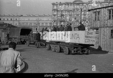 Warszawa, 1948-10-20. Zniszczona w styczniu 1945 r. Kolumna Zygmunta III Wazy zosta³a odbudowana z inicjatywy pracowników Pañstwowych Kamienio³omów. Trzon kolumny wykuto z 30-tonowego bloku granitowego o d³ugoœci 10 metrów, wydobytego w kamienio³omie ¯bik w Strzegomiu i przewiezionego kolej¹ do Warszawy. Dalej Transport odbywa³ siê na specjalnej lawecie, której obs³ugê stanowili robotnicy firmy C. Hartwig: Zaj¹c, Glinka, Janke, czy¿ewski, Dembowski, Wnuk i Kisiel. NZ. kolumna transportowa na ul. Szpitalnej. pw PAP Warschau, 20. Oktober 1948. Der König König Sigismundus III Vasa Spalte Zerstöre Stockfoto