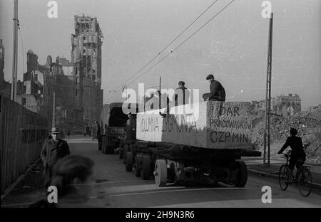 Warszawa, 1948-10-20. Zniszczona w styczniu 1945 r. Kolumna Zygmunta III Wazy zosta³a odbudowana z inicjatywy pracowników Pañstwowych Kamienio³omów. Trzon kolumny wykuto z 30-tonowego bloku granitowego o d³ugoœci 10 metrów, wydobytego w kamienio³omie ¯bik w Strzegomiu i przewiezionego kolej¹ do Warszawy. Dalej Transport odbywa³ siê na specjalnej lawecie, której obs³ugê stanowili robotnicy firmy C. Hartwig: Zaj¹c, Glinka, Janke, czy¿ewski, Dembowski, Wnuk i Kisiel. NZ. kolumna transportowa na placu Napoleona (Powstañców Warszawy). Z lewej wypalony budynek Towarzystwa Ubezpieczeñ Prudential. pw Stockfoto