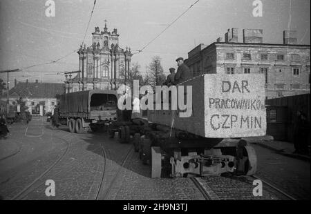 Warszawa, 1948-10-20. Zniszczona w styczniu 1945 r. Kolumna Zygmunta III Wazy zosta³a odbudowana z inicjatywy pracowników Pañstwowych Kamienio³omów. Trzon kolumny wykuto z 30-tonowego bloku granitowego o d³ugoœci 10 metrów, wydobytego w kamienio³omie ¯bik w Strzegomiu i przewiezionego kolej¹ do Warszawy. Dalej Transport odbywa³ siê na specjalnej lawecie, której obs³ugê stanowili robotnicy firmy C. Hartwig: Zaj¹c, Glinka, Janke, czy¿ewski, Dembowski, Wnuk i Kisiel. NZ. kolumna transportowa na ul. Królewskiej, skrêca w ul. Krakowskie Przedmieœcie. W g³êbi barokowy koœció³ pw. œw. Józefa Oblubieñ Stockfoto