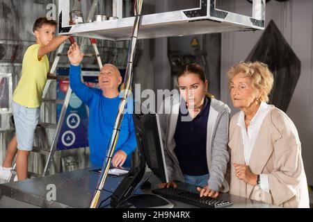 Großeltern und Enkelkinder, die sich im Fluchtzimmer mit einem Konundrommel herumtoben Stockfoto