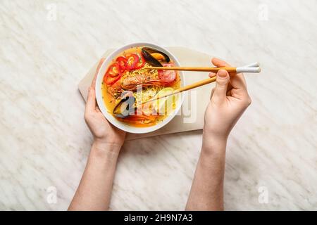 Frau, die schmackhafte Thai-Suppe aus der Schüssel isst Stockfoto