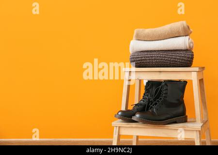 Stilvolle Winterkleidung auf der Leiter im Zimmer Stockfoto